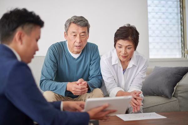 Elderly couple receiving Bitcoin ATM fraud advice from consultant.