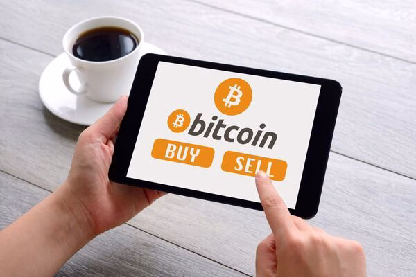Persona que usa una tableta para acceder a las opciones de compra y venta de Bitcoin.