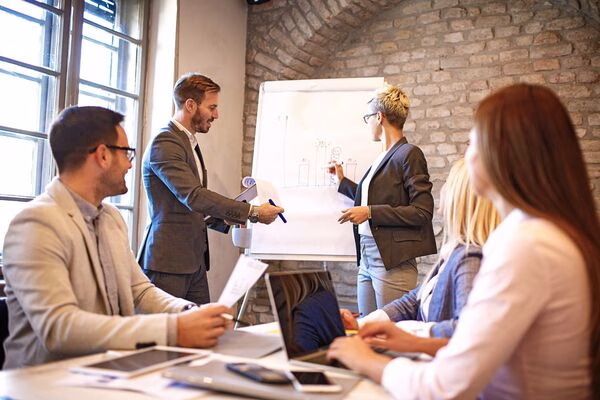 Equipo empresarial discutiendo la estrategia de pagos transfronterizos con un gráfico
