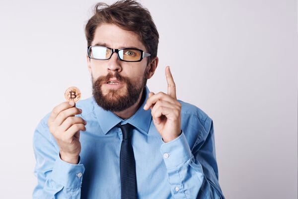Empresario explicando el concepto de cajero automático de Bitcoin con monedas
