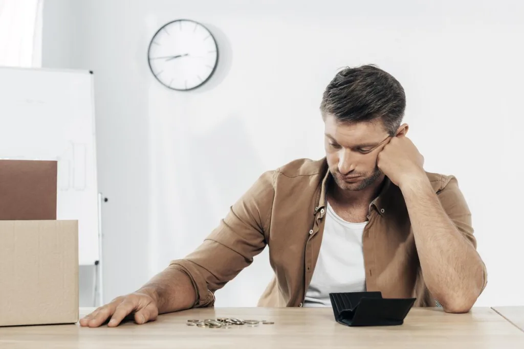 Hombre frustrado esperando que llegue su transferencia de dinero retrasada