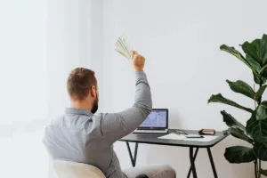 Hombre que sostiene efectivo mientras se prepara para transferir dinero