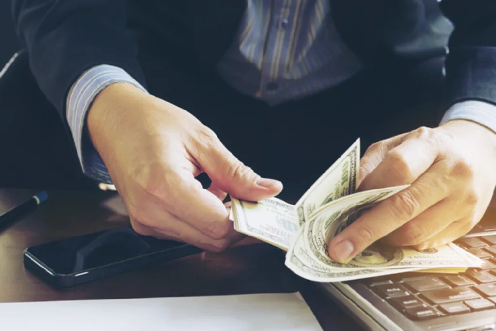 Businessman counting US dollars for money transfer process.