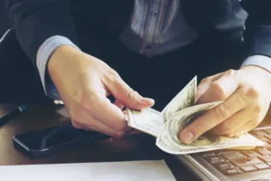 Businessman counting US dollars for money transfer process.