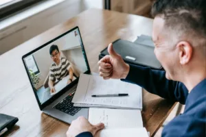 Man giving thumbs up while confirming Money Transfer on video call