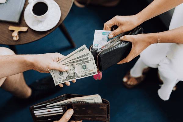 Manos intercambiando efectivo por transferencias de dinero personal