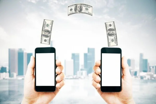 Concepto de transferencia de dinero digital que muestra efectivo moviéndose entre teléfonos inteligentes.
