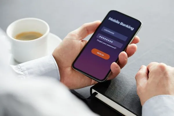 Hand holding smartphone to start online Money Transfer process