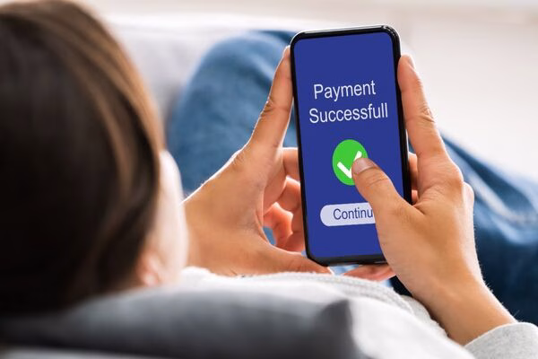 Mujer confirma pagos transfronterizos a través de la interfaz de la aplicación para teléfono inteligente.