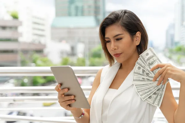 Mujer que revisa las opciones de transferencia de dinero en una tableta digital
