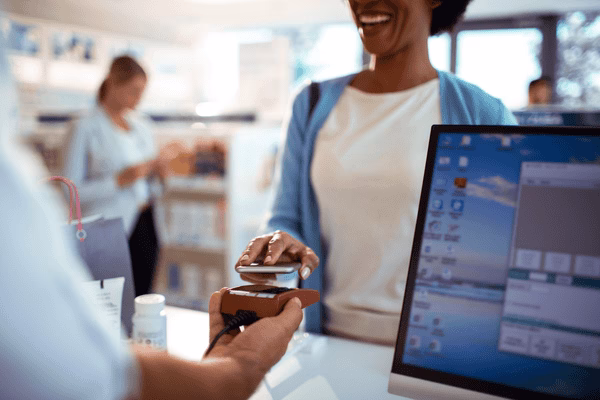 Cliente sonriente realizando un pago transfronterizo en una tienda
