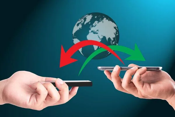 Transferencia de dinero entre teléfonos inteligentes con ilustración de globo terráqueo y flechas.