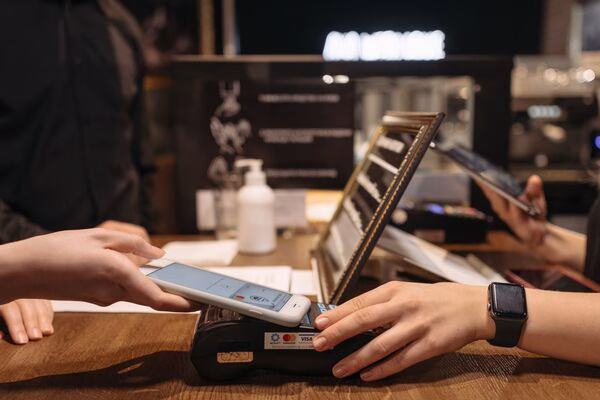  Comerciante procesa pagos transfronterizos a través de un terminal de pago inteligente.
