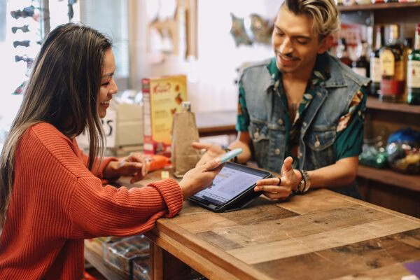 Smiling customer makes Cross Border Payments via mobile app.