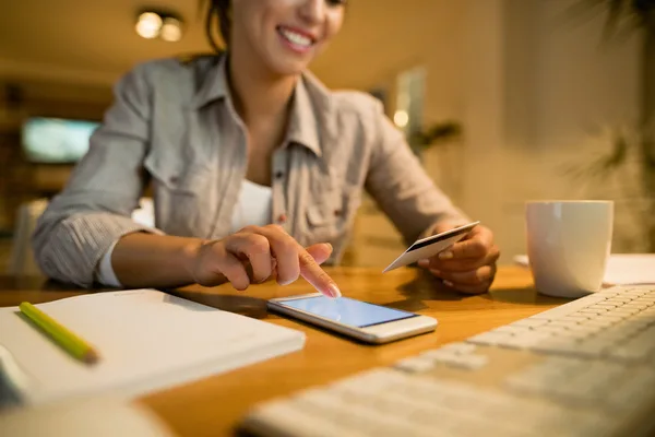 Smiling woman making a money transfer via mobile banking app.