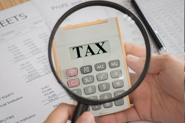 Calculadora con texto “IMPUESTO” relacionado con los informes de transferencias de dinero.
