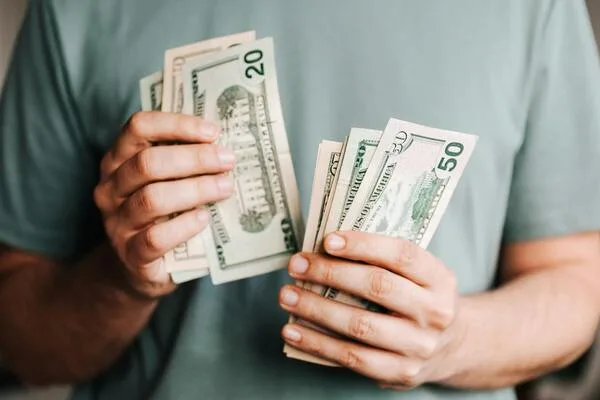 Persona que tiene efectivo mientras considera el mejor valor en transferencias de dinero
