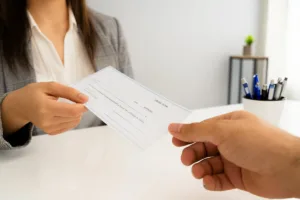 Una persona entrega un cheque personal para cobrar