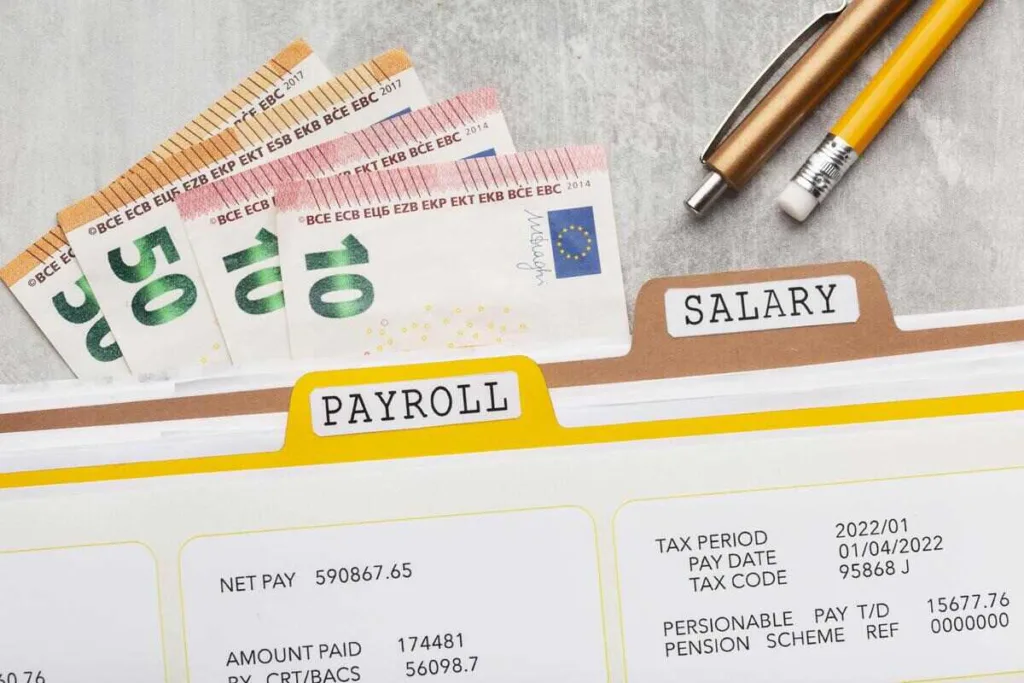 Cheques de nómina y documentos salariales con billetes de euros