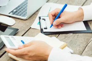 Persona escribiendo pautas comerciales de cobro de cheques en papel