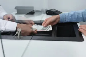 Cajero entrega efectivo a través de una ventanilla de servicio para apoyar a pequeñas empresas
