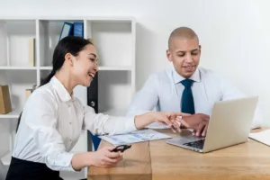 Dos profesionales discutiendo los plazos de cobro de cheques en una computadora portátil