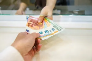 Cajero de banco entregando efectivo durante el proceso de cobro de cheques