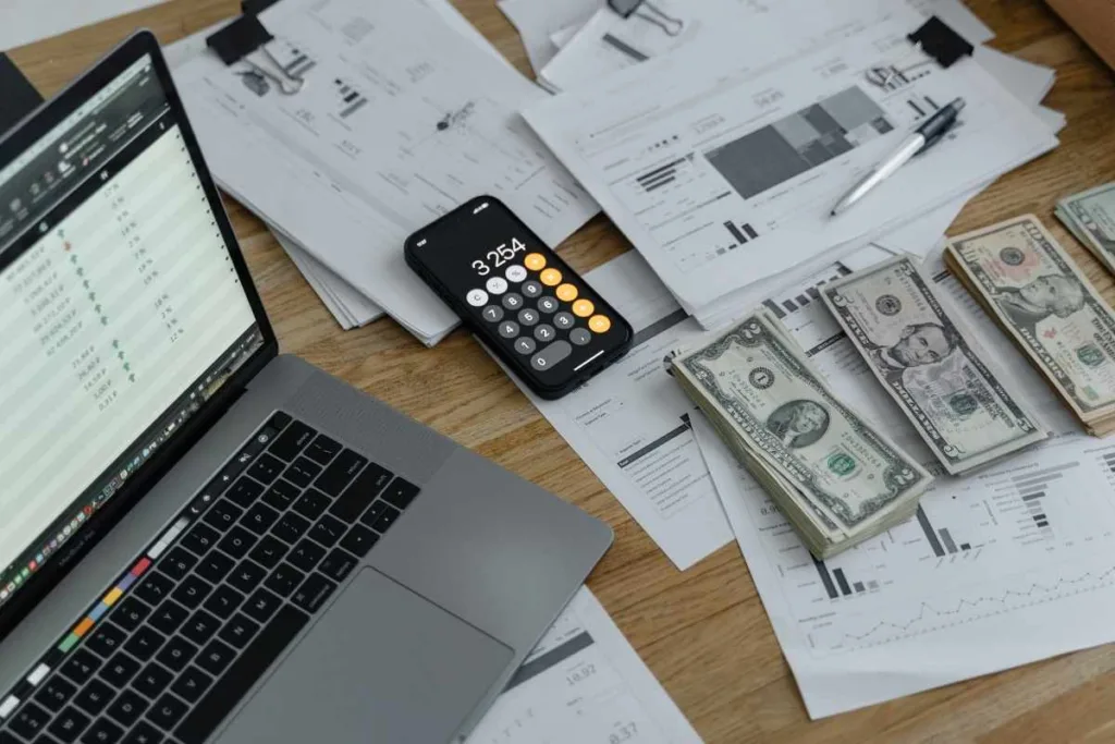 Preparación para el cobro de cheques con calculadora de dinero y computadora portátil