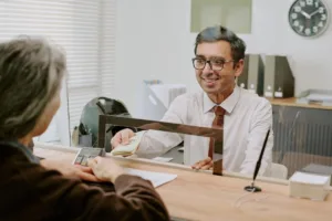 Cajero que ayuda a un cliente con un servicio seguro de cobro de cheques