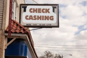 Check cashing storefront sign showing hours to cash a check.