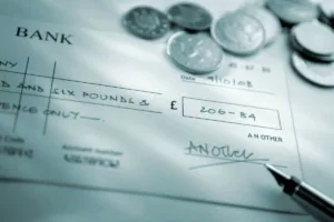 Closeup of bank check with coins used to cash a check.