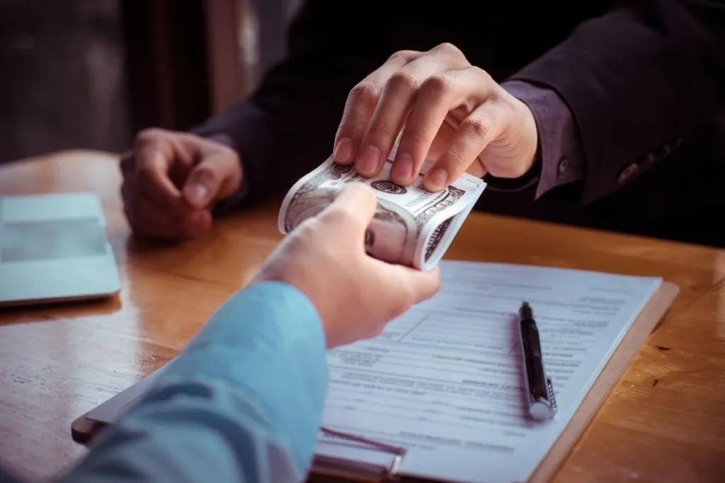 Money Transfer exchange with cash, documents, and pen on desk.