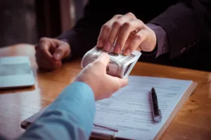 Money Transfer exchange with cash, documents, and pen on desk.
