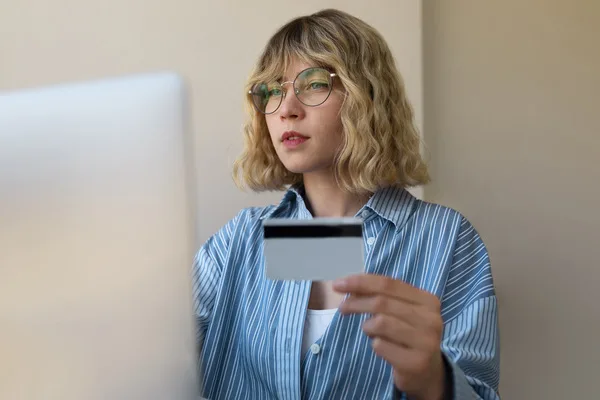 Woman holding ID card for check cashing
