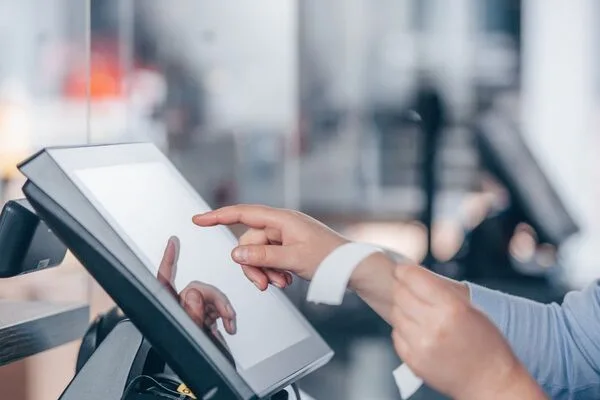  Cashier using touchscreen register system to help customers Cash Checks.
