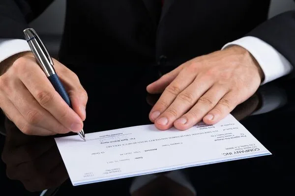 Persona que completa un cheque bancario antes del proceso de cobro del cheque.