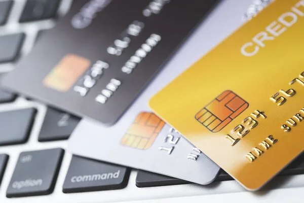 Multiple credit cards on laptop keyboard used for Money Transfer.

