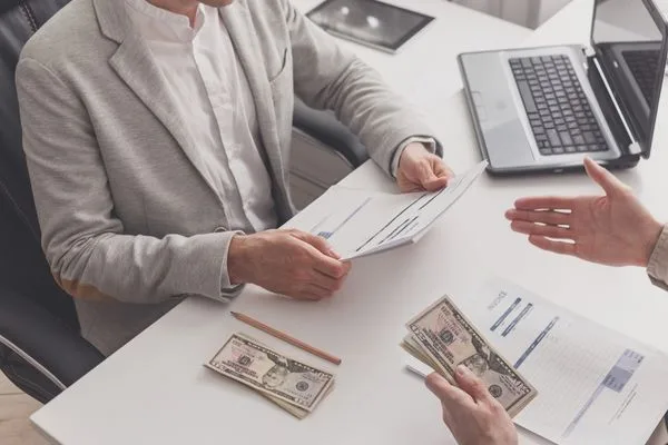 Transferencia de dinero en la oficina con efectivo y documentos
