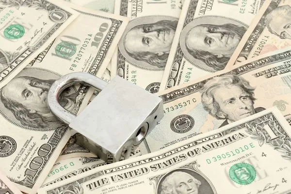 Concepto de cobro seguro de cheques con candado en billetes de dólar