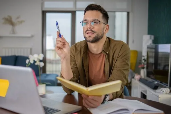 Focused man holding notebook and pen researching Check Cashing tips