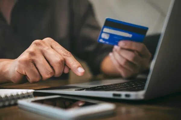 Person using laptop and credit card for online Money Transfer