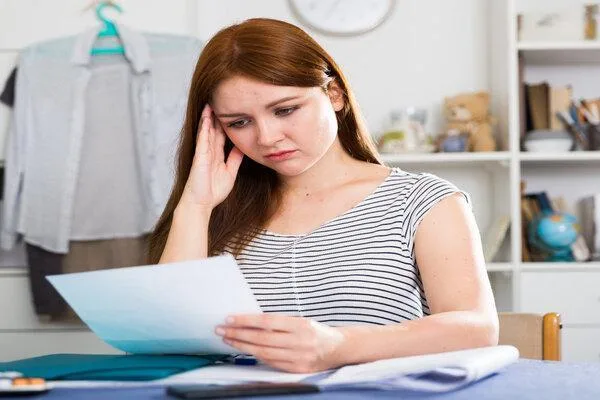Mujer preocupada por un cheque de pago vencido antes de cobrarlo
