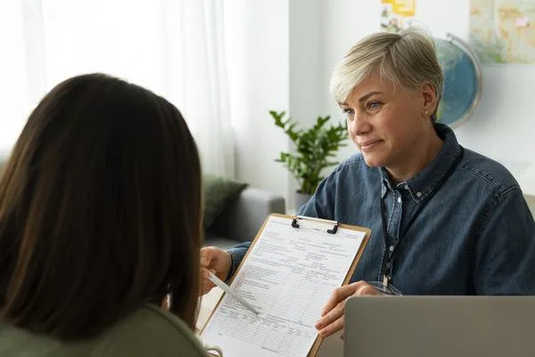 Mujer discutiendo los detalles de vencimiento del cheque de seguro con un asesor