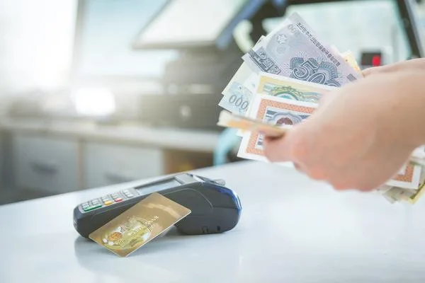 una persona sostiene billetes con un pago durante el cobro de un cheque comercial 
