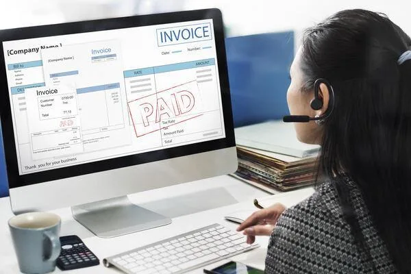 Employee reviewing payroll invoice with paid confirmation