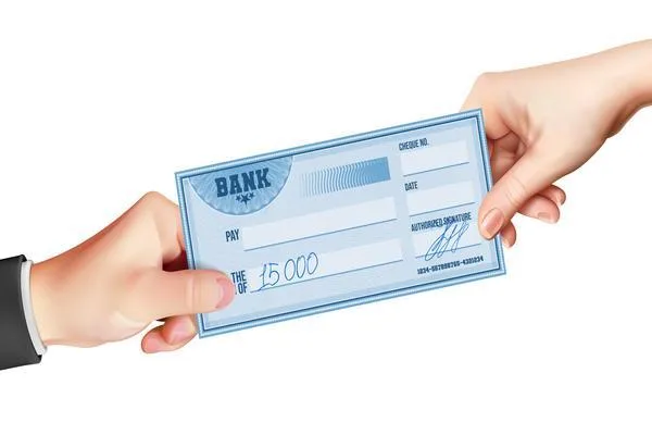 Dos manos que intercambian un cheque bancario para cobrar 
