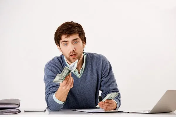 Un hombre cuenta efectivo después de cobrar un cheque de reembolso