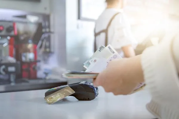  Person handling cash and card at payment counter