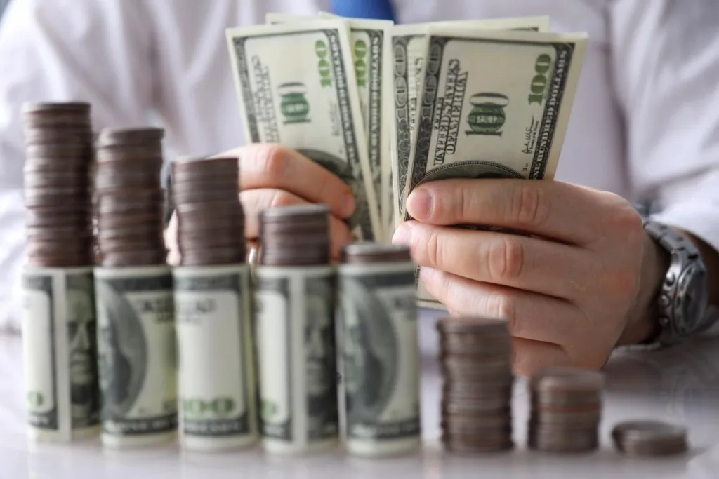 Proceso de cobro de cheques con monedas apiladas y billetes de dólar