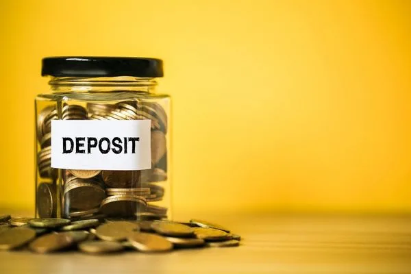 Coins in deposit jar representing check cashing deposits